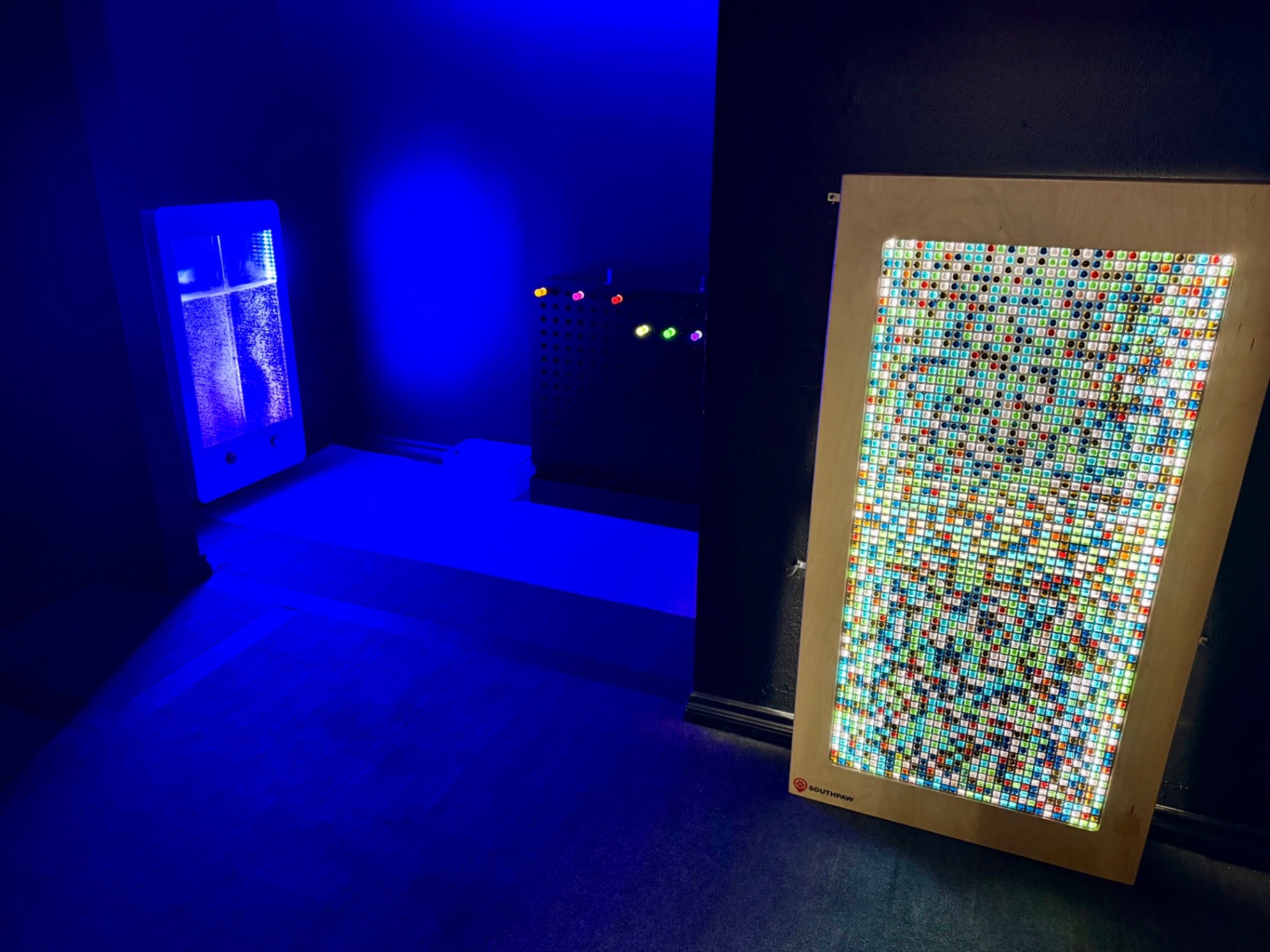 Calming sensory room with bubble tube and LED light panel at Arcadia