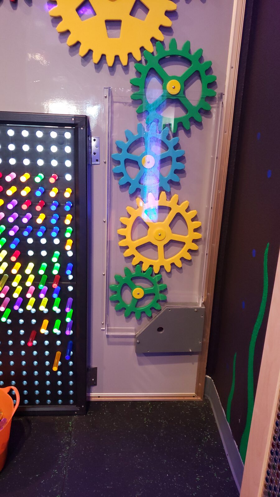Colorful gear and LED light sensory wall in the Waco play gym