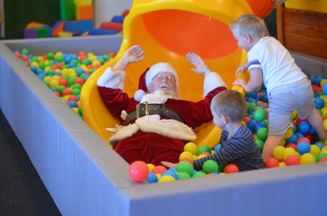 Smiling preschooler in helmet and harness exploring the indoor ropes course